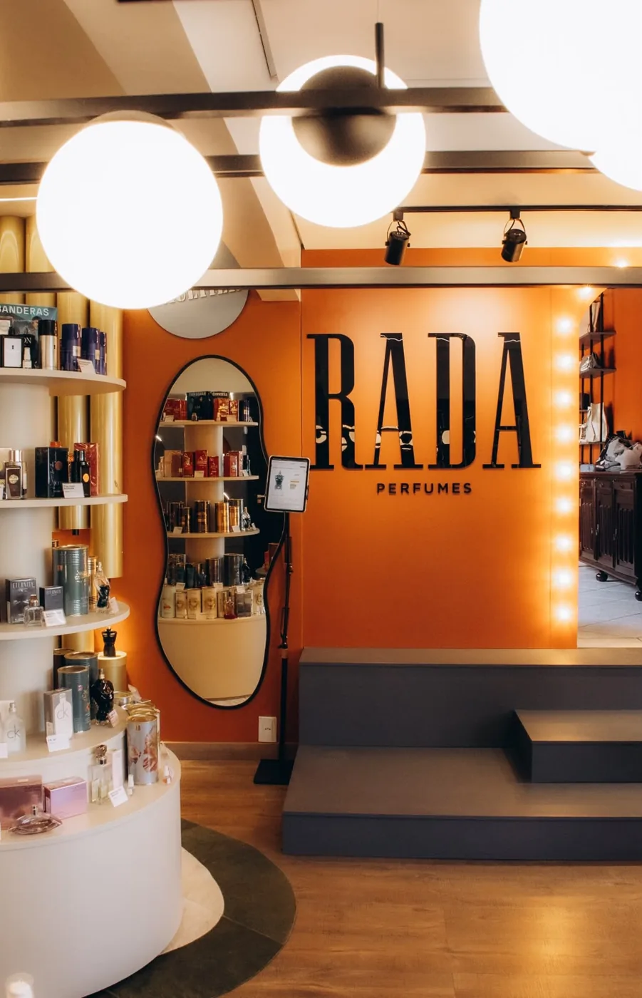 Interior da loja Rada Perfumes em Xanxerê, com a parede terracota e o letreiro Rada