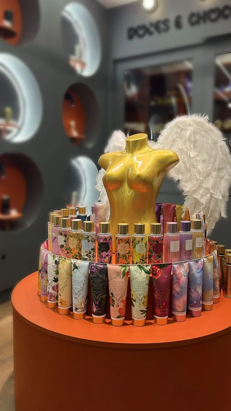 Expositor de body splash Victoria's Secret com busto dourado e asas